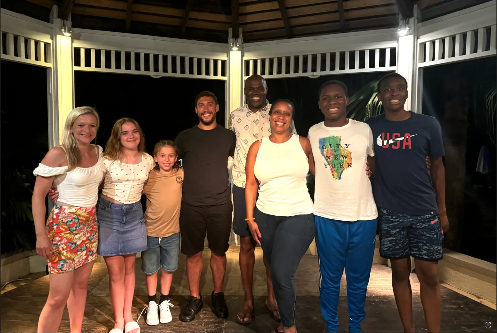 A family gathering at night under a wooden gazebo
